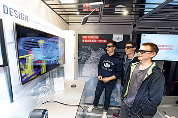 Bild zeigt drei Schüler mit 3D-Brillen vor einem Bildschirm im Discover-Industry-Truck