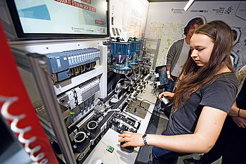 Bild zeigt eine Schülerin an einer Miniatur-Produktionsstraße im Discover-Industry-Truck
